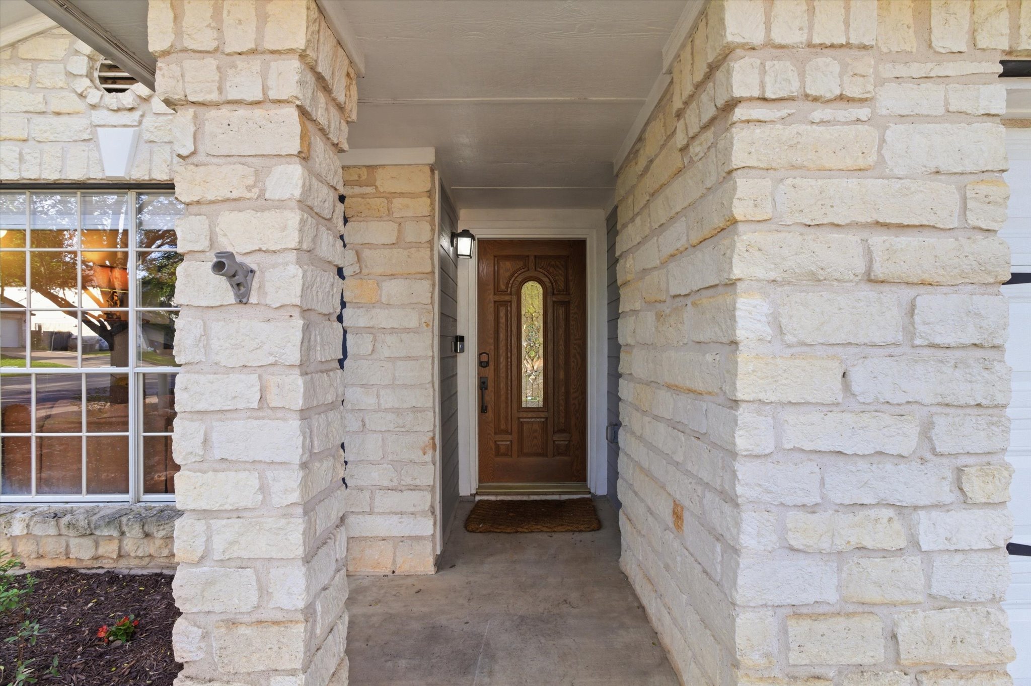 8920 West Hove Loop Austin, TX 78749 - Photo 23 of 39 Stone facade entry with a paneled wood-finish front door featuring decorative glass