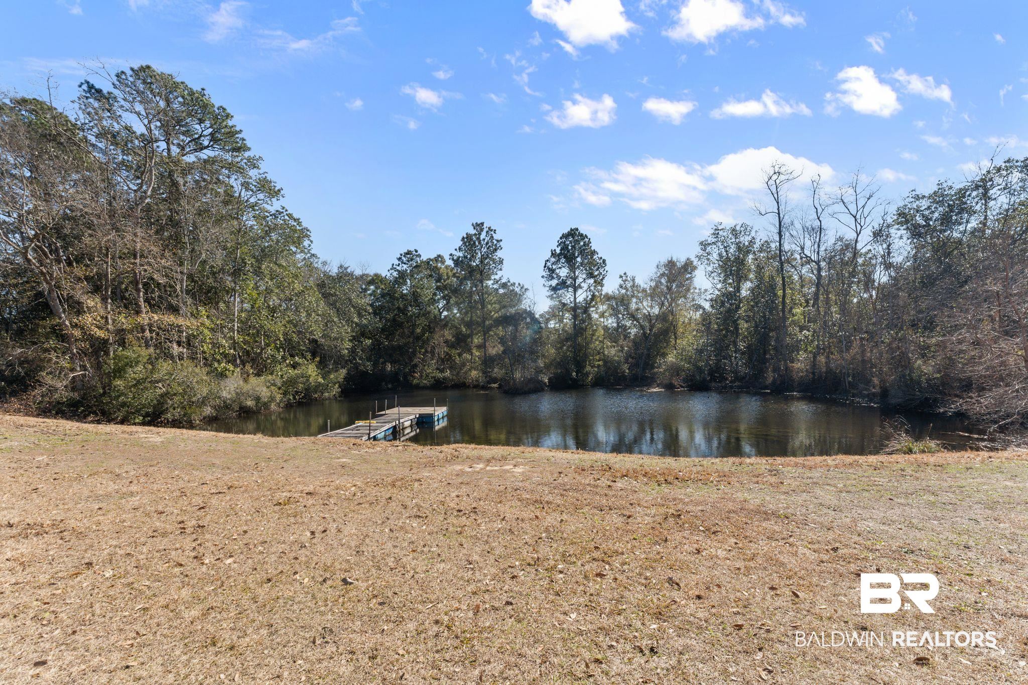 32989 Antietam Road Lillian, AL 36549 - Photo 4 of 56 Water view with a floating dock and a heavily wooded area
