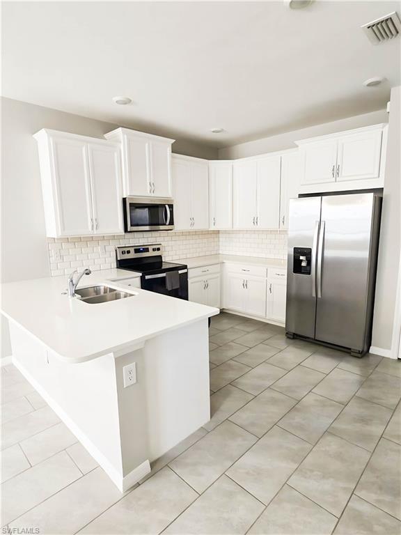 1264 Enbrook Loop Naples, FL 34114 - Photo 12 of 27 a kitchen with cabinets and white stainless steel appliances