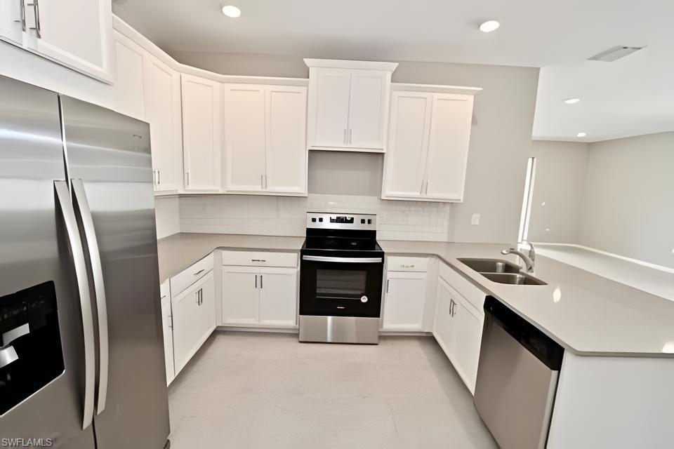 1264 Enbrook Loop Naples, FL 34114 - Photo 13 of 27 a kitchen with stainless steel appliances granite countertop a sink stove and refrigerator