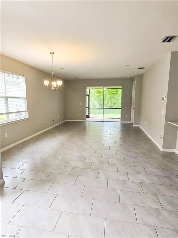 1264 Enbrook Loop Naples, FL 34114 - Photo 16 of 27 an empty room with chandelier fan and windows