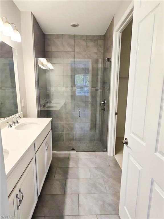 1264 Enbrook Loop Naples, FL 34114 - Photo 8 of 27 a bathroom with a granite countertop sink a mirror a shower and a tub