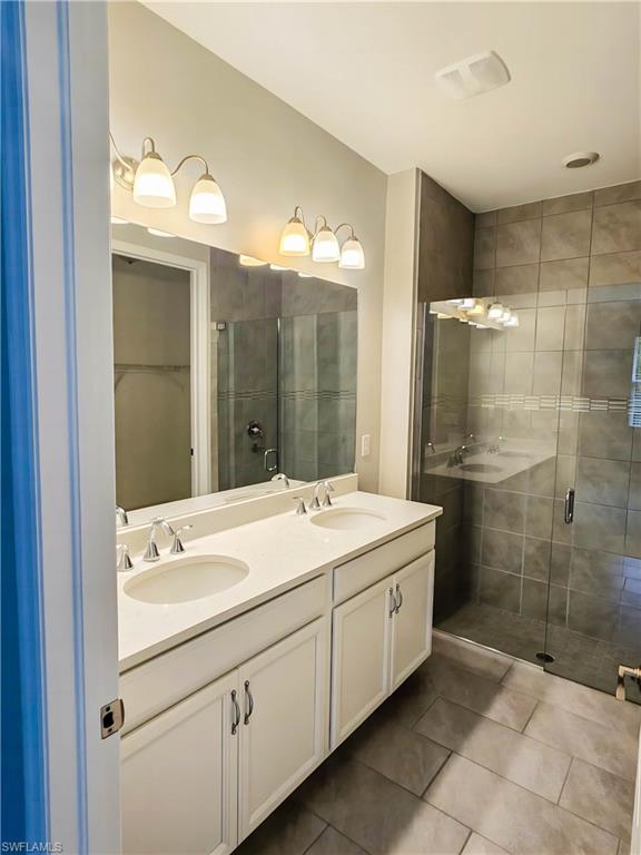 1264 Enbrook Loop Naples, FL 34114 - Photo 9 of 27 a bathroom with a double vanity sink mirror and shower