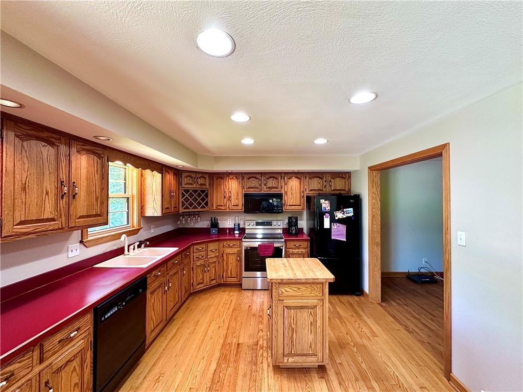 752 Covered Bridge Road Volant, PA 16156 - Photo 14 of 48 a kitchen with stainless steel appliances granite countertop a sink dishwasher a refrigerator and wooden floor