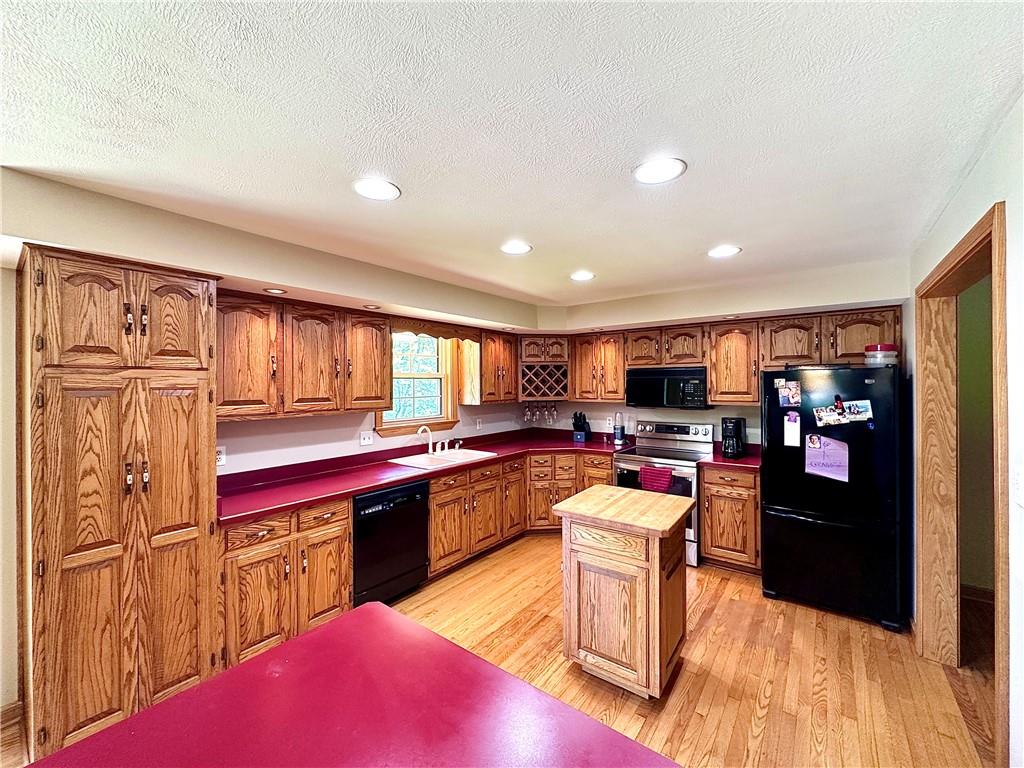 752 Covered Bridge Road Volant, PA 16156 - Photo 15 of 48 a kitchen with stainless steel appliances kitchen island granite countertop a stove refrigerator and cabinets