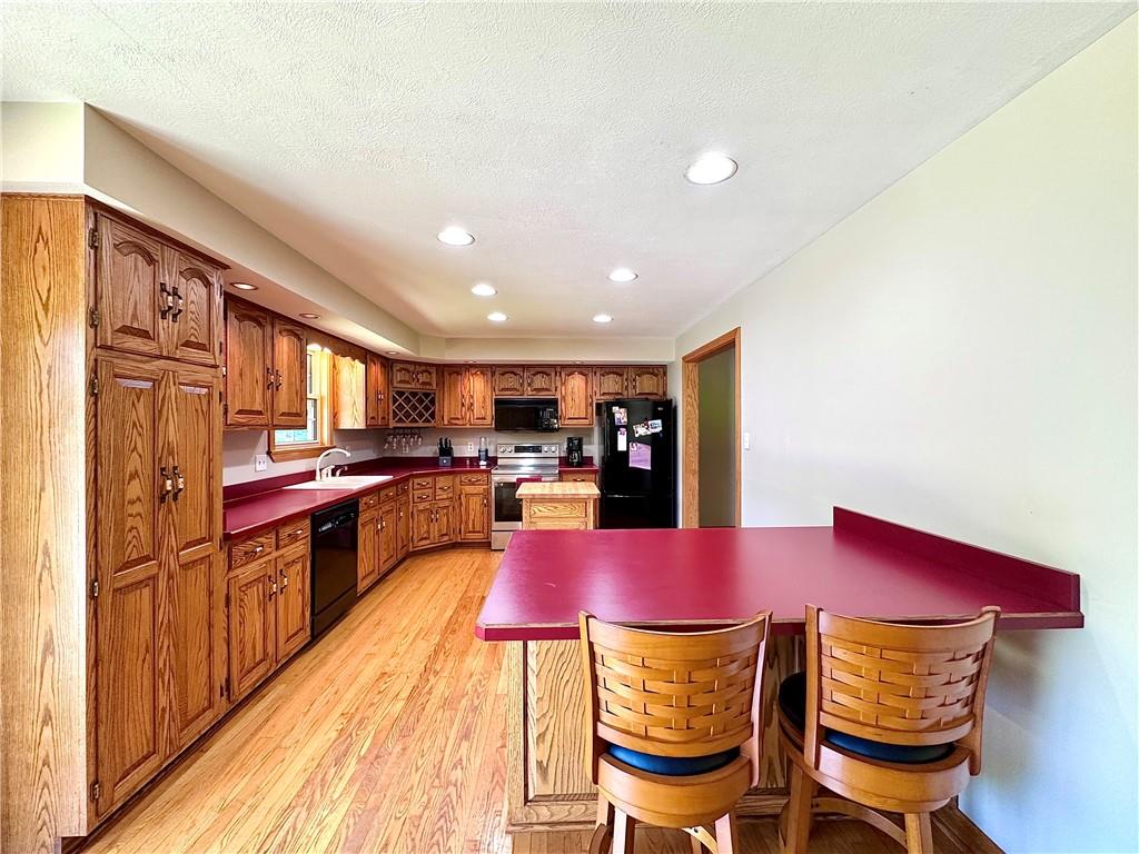 752 Covered Bridge Road Volant, PA 16156 - Photo 17 of 48 a kitchen with a dining table chairs cabinets and stainless steel appliances