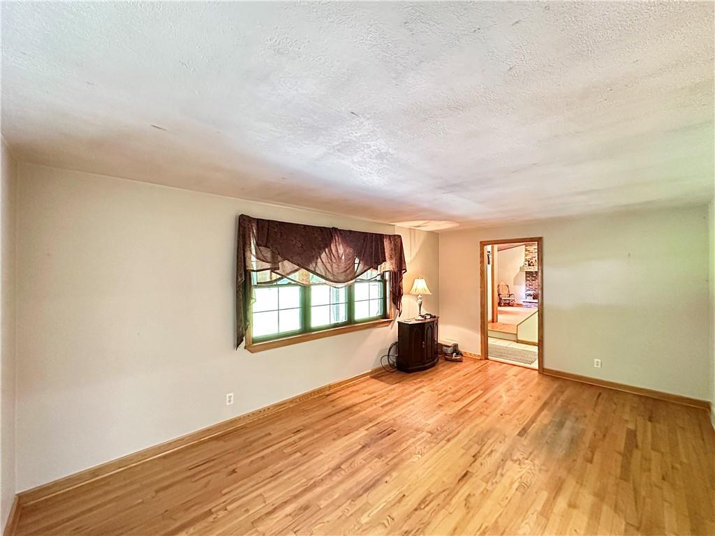 752 Covered Bridge Road Volant, PA 16156 - Photo 21 of 48 an empty room with wooden floor and windows