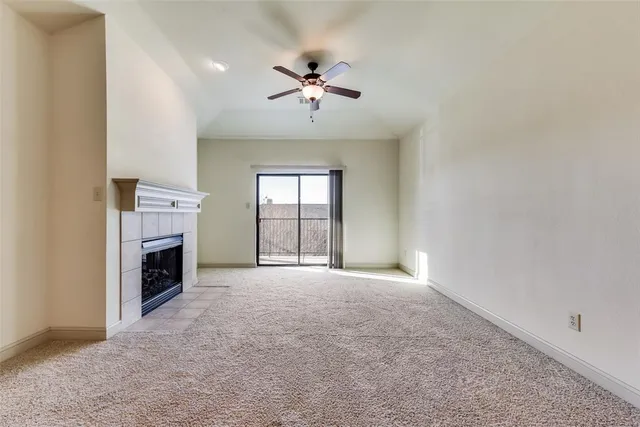 a view of a livingroom with a fireplace and ceiling fan