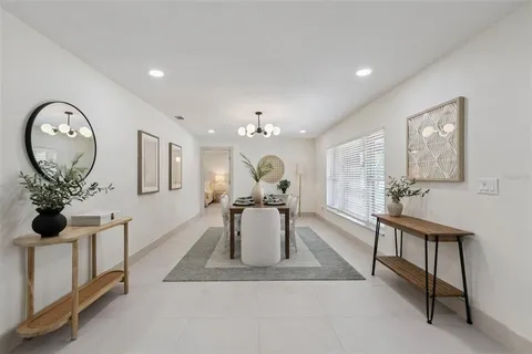 a living room with furniture a chandelier and a large window