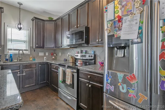 a kitchen with stainless steel appliances granite countertop a refrigerator and a sink