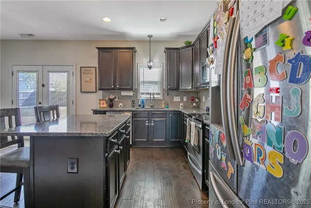 a kitchen with stainless steel appliances granite countertop a sink and a stove top oven
