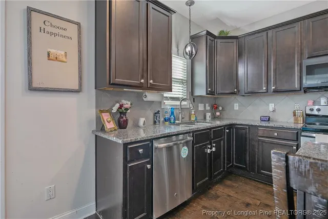a kitchen with stainless steel appliances granite countertop a sink stove and cabinets