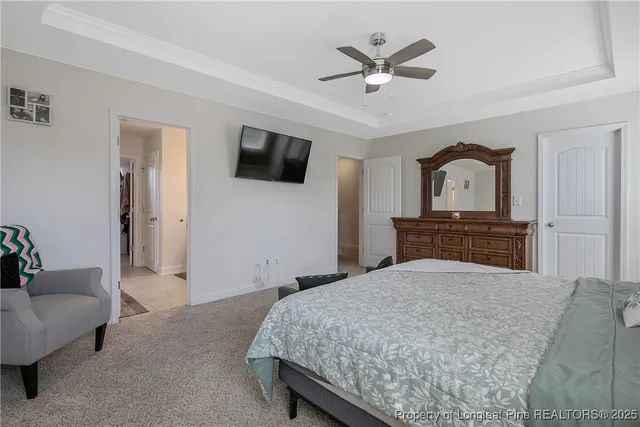 a bedroom with a bed a couch and a flat screen tv