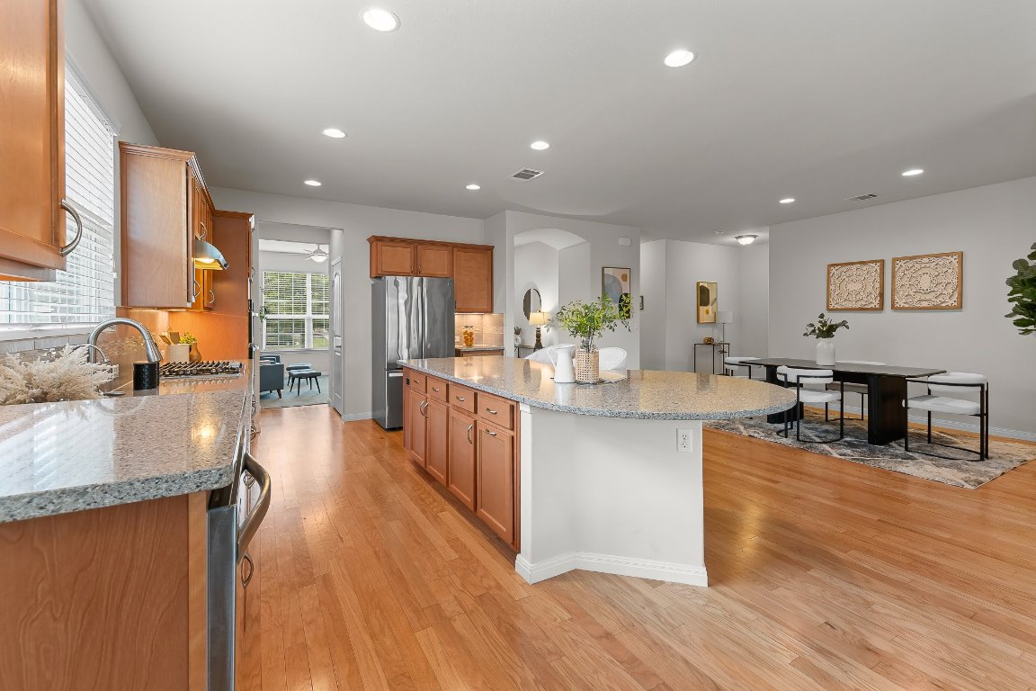 608 Kite Ridge Street Georgetown, TX 78633 - Photo 19 of 39 a kitchen with stainless steel appliances granite countertop wooden floors a stove and a sink