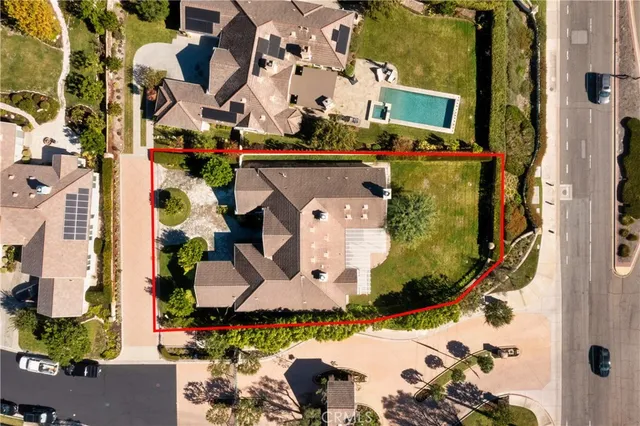 an aerial view of a house with a yard and a large tree