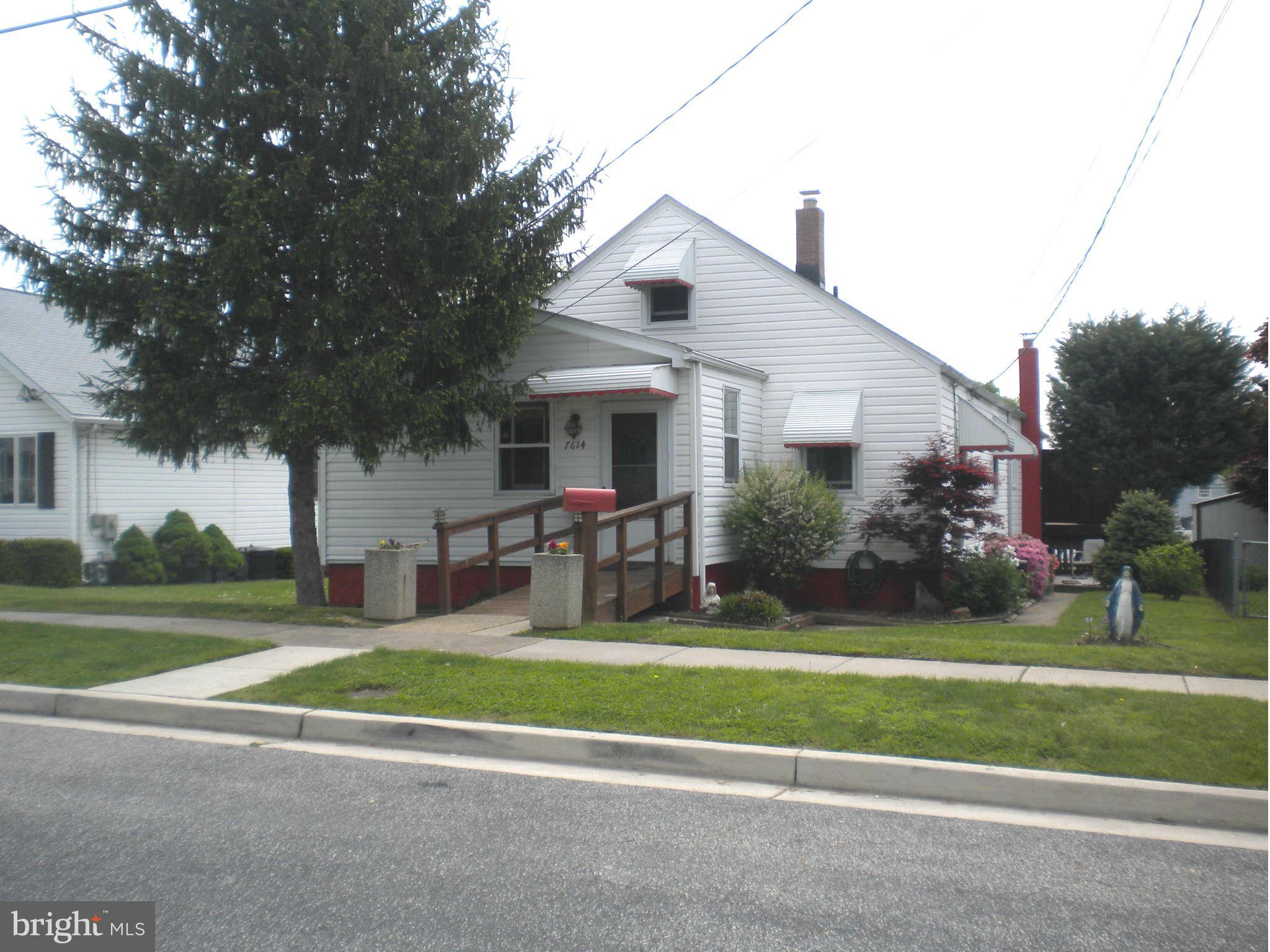 7614 Spruce Road Baltimore, MD 21222 - Photo 1 of 30 a front view of a house with a yard table and chairs