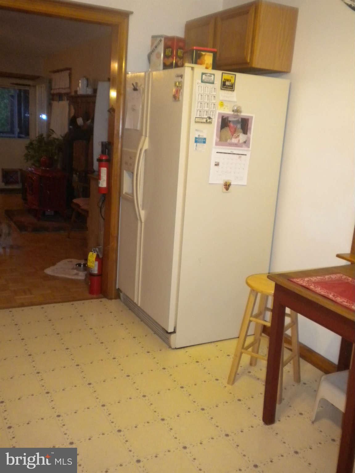 7614 Spruce Road Baltimore, MD 21222 - Photo 17 of 30 a white refrigerator freezer sitting next to a wall