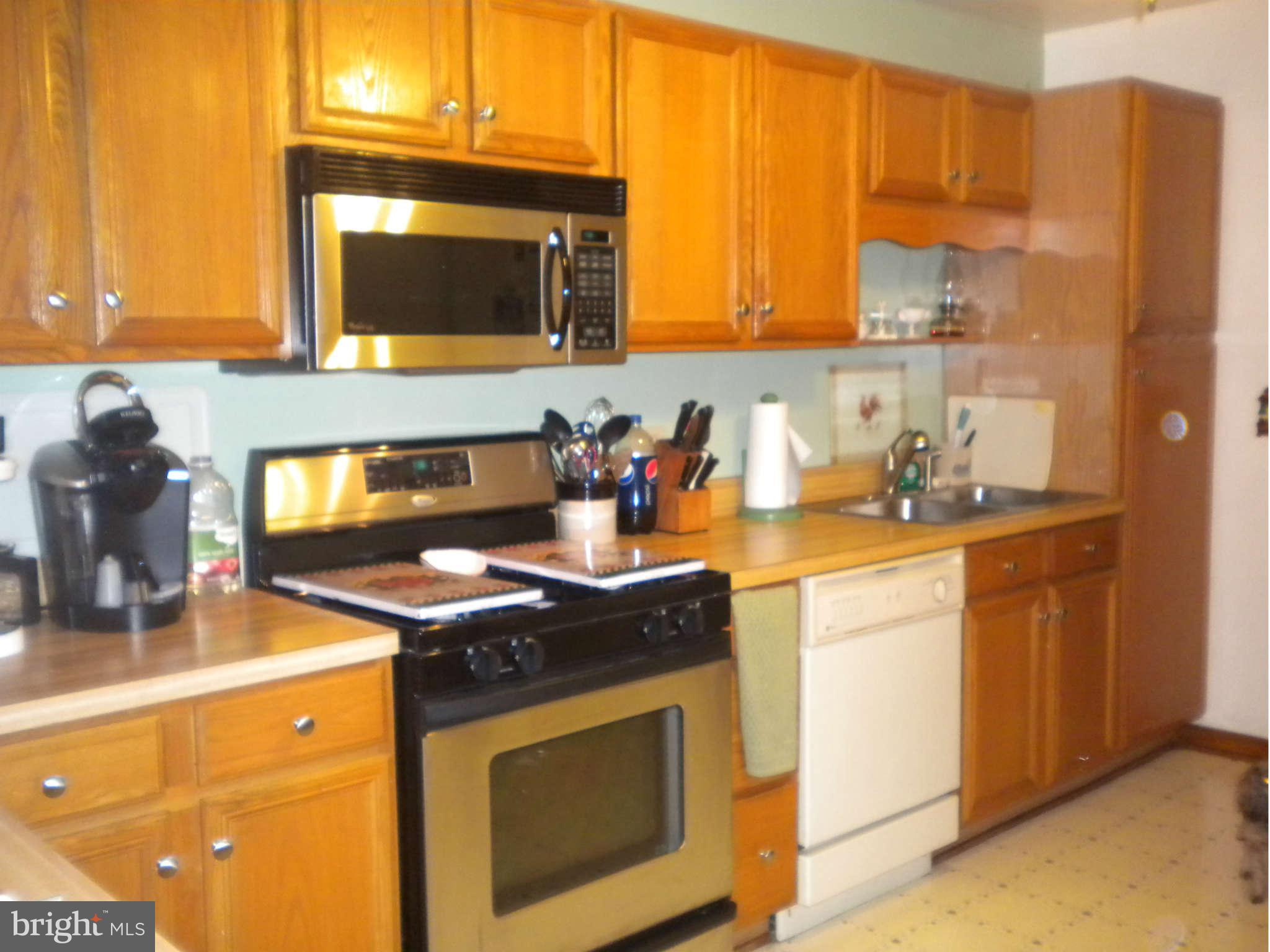7614 Spruce Road Baltimore, MD 21222 - Photo 21 of 30 a kitchen with stainless steel appliances granite countertop a stove a sink and a microwave