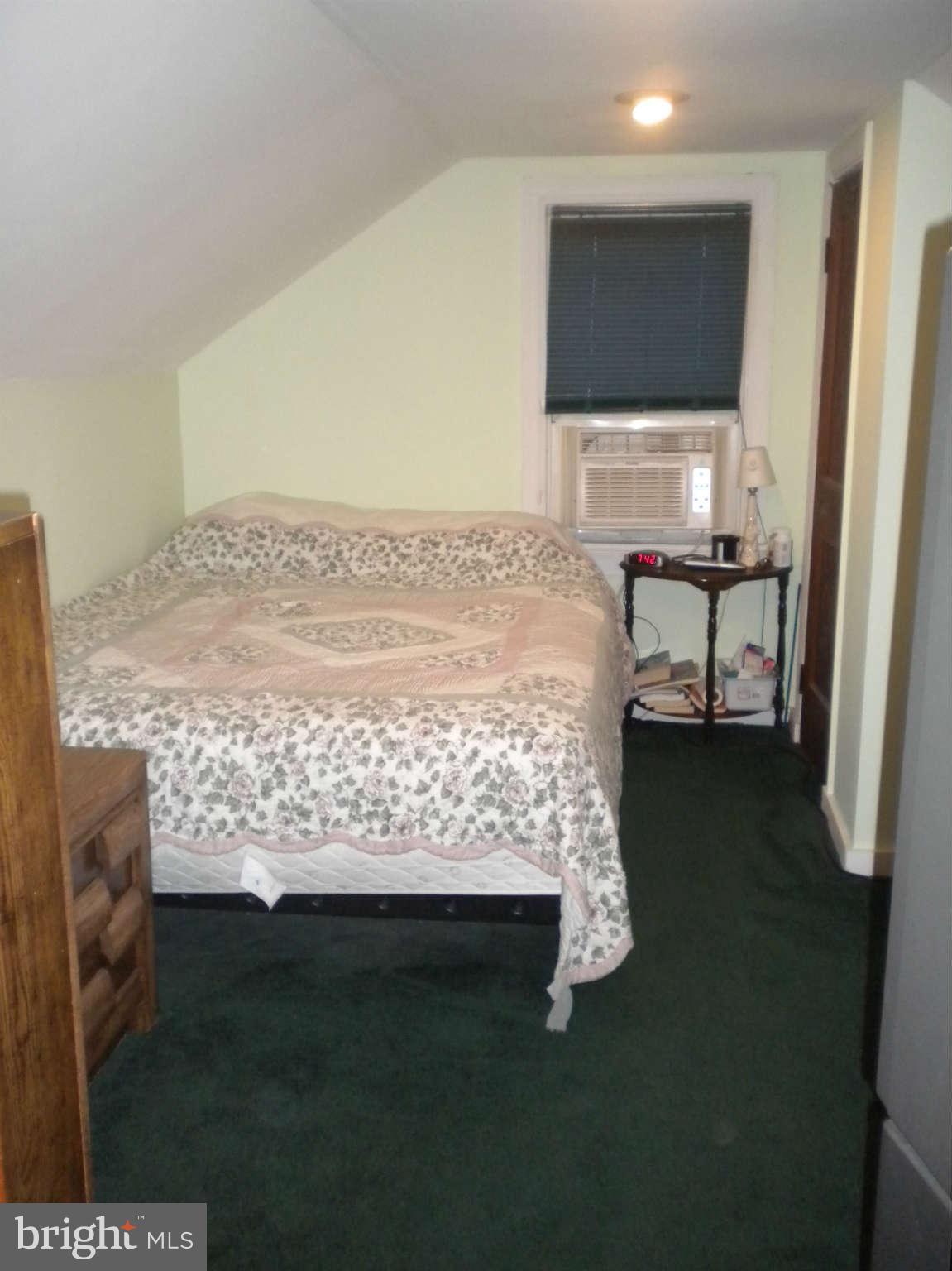 7614 Spruce Road Baltimore, MD 21222 - Photo 29 of 30 a bed sitting in a bedroom next to a window
