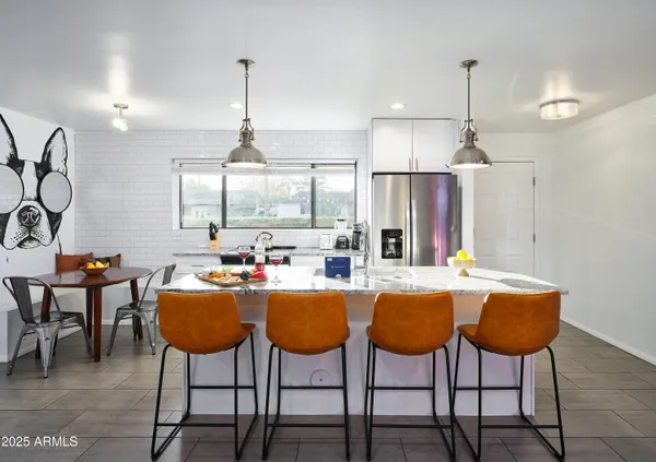 a dining table chairs and a chandelier in a room
