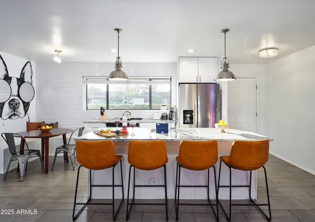 a dining table chairs and a chandelier in a room