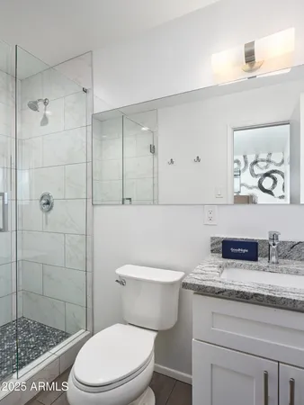 a bathroom with a granite countertop toilet sink and shower