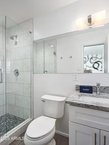 a bathroom with a granite countertop toilet sink and shower