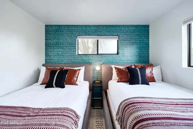 a bedroom with two beds and a wooden floor