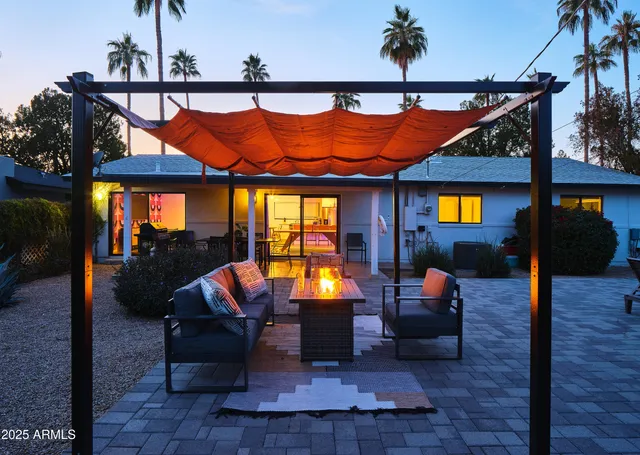 an outdoor living room with furniture and wooden floor
