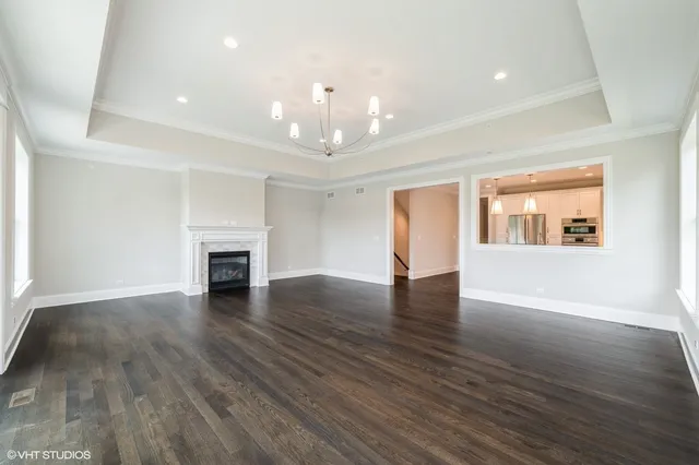 a view of an empty room with a window and chandelier