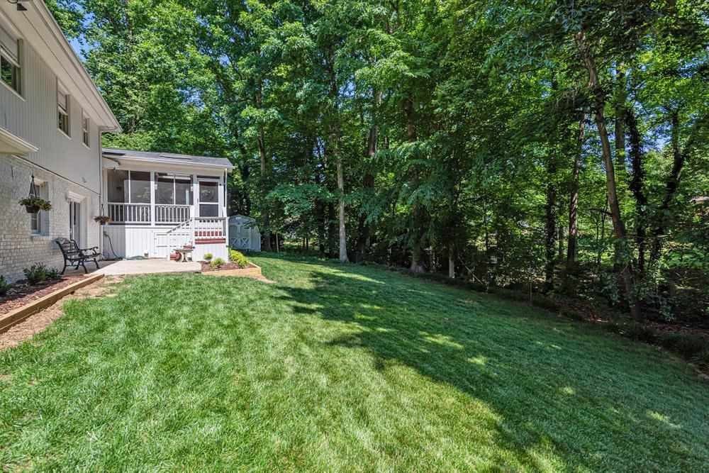 509 Compton Road Raleigh, NC 27609 - Photo 25 of 30 Large fenced in backyard with screened porch, stairs to lower patio, and storage shed. Backyard