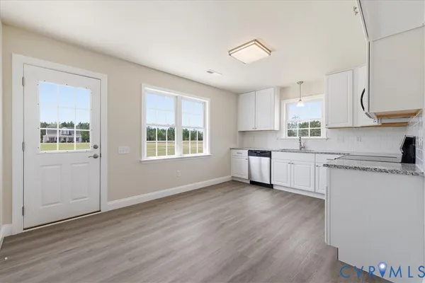 a kitchen with stainless steel appliances a white stove top oven sink and cabinets with wooden floor