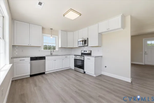 a kitchen with granite countertop white cabinets and white appliances