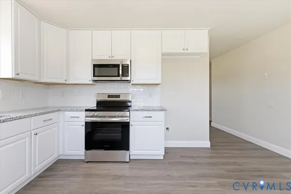 a kitchen with white cabinets and stainless steel appliances