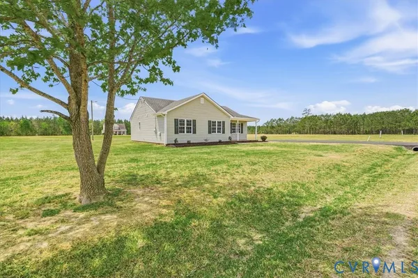 a view of a house with a big yard and large trees