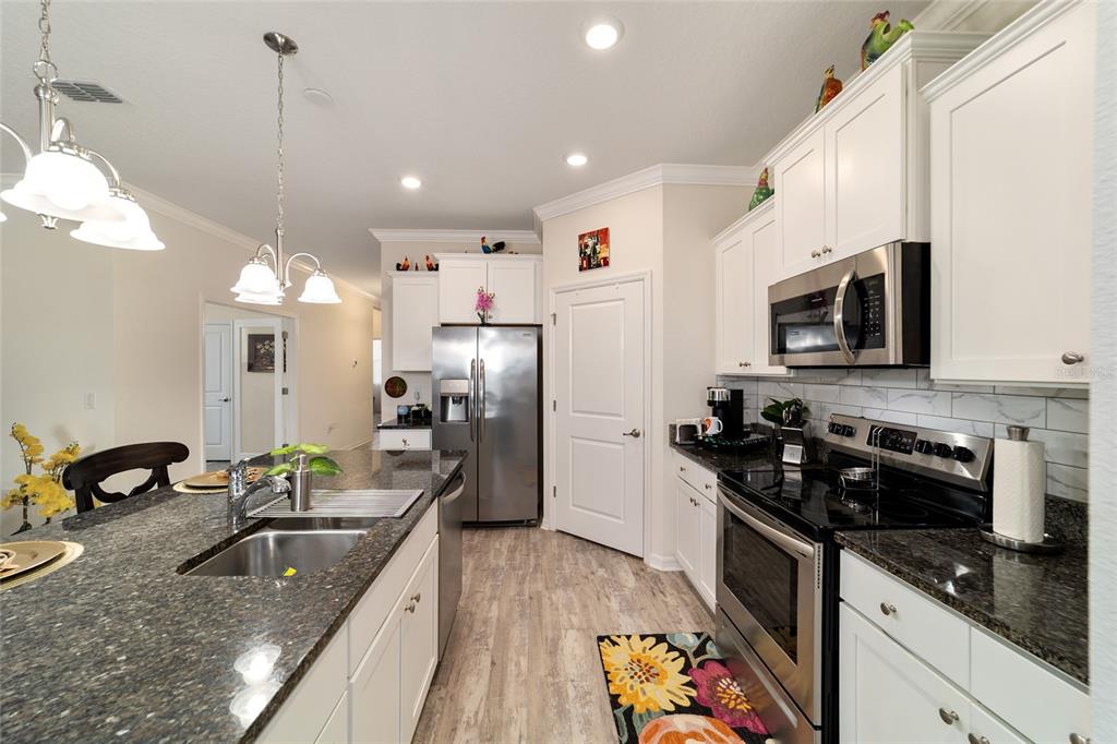 9238 Southwest 60th Terrace Road Ocala, FL 34476 - Photo 21 of 50 a kitchen with stainless steel appliances granite countertop a sink a stove and a refrigerator