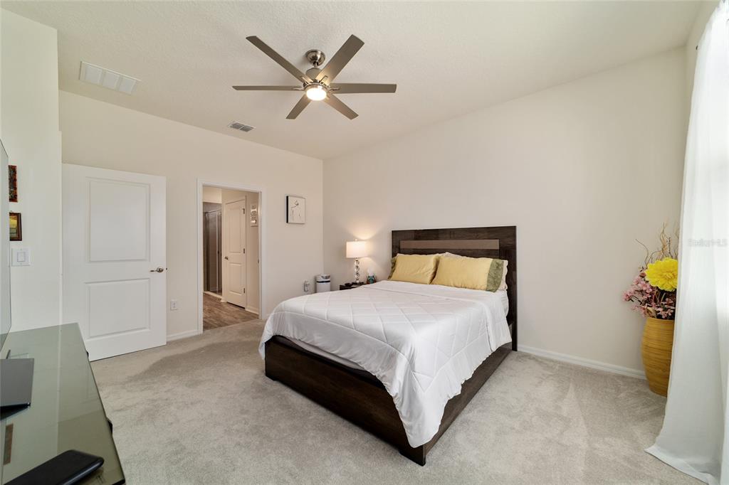 9238 Southwest 60th Terrace Road Ocala, FL 34476 - Photo 29 of 50 a bedroom with a bed and a chandelier