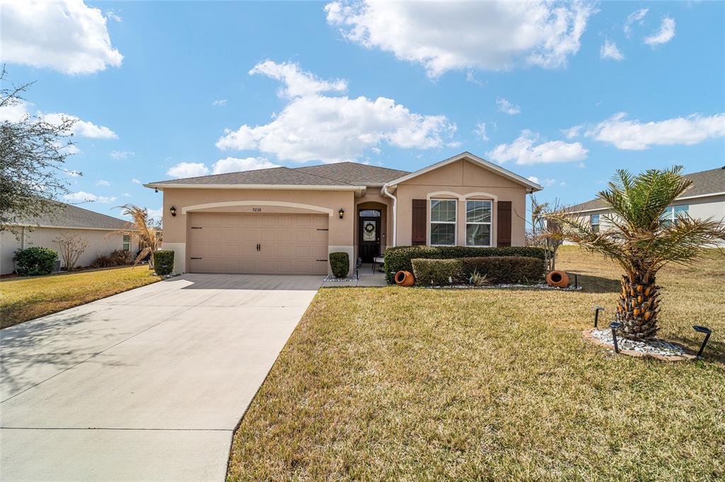 9238 Southwest 60th Terrace Road Ocala, FL 34476 - Photo 3 of 50 a front view of a house with a yard and garage
