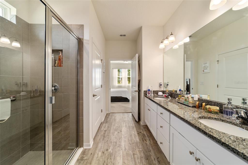 9238 Southwest 60th Terrace Road Ocala, FL 34476 - Photo 32 of 50 a spacious bathroom with a granite countertop sink mirror and a shower
