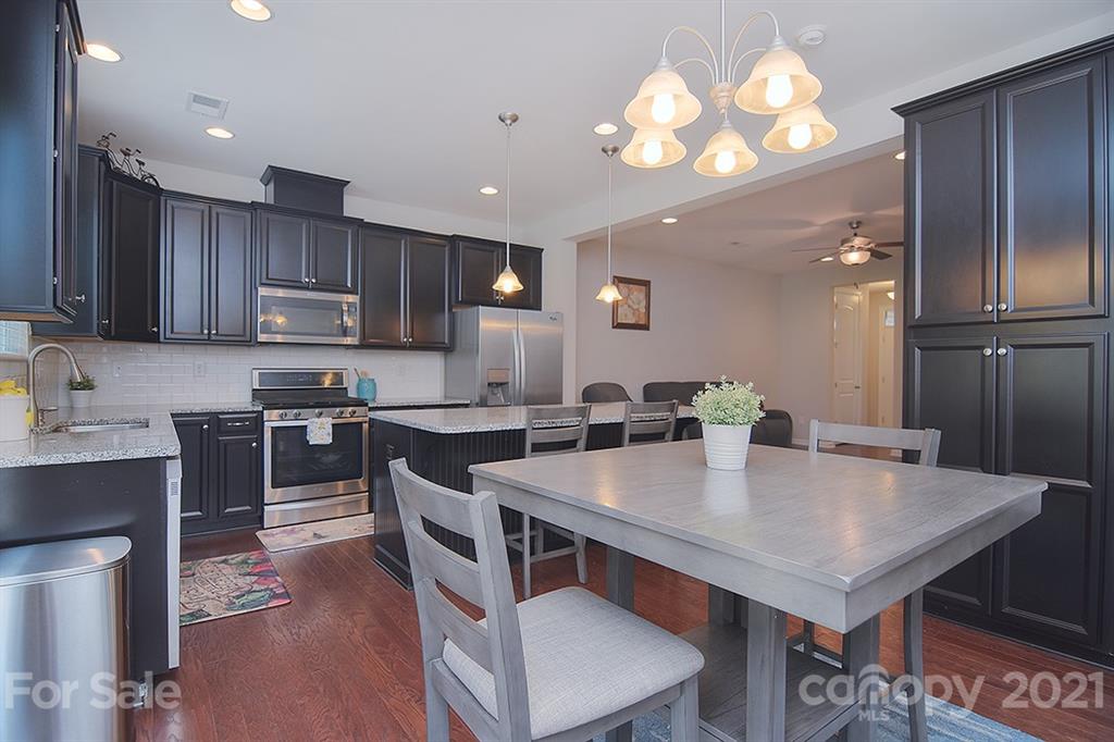 1411 Calum Way Fort Mill, SC 29708 - Photo 12 of 37 a kitchen with a table chairs microwave and cabinets