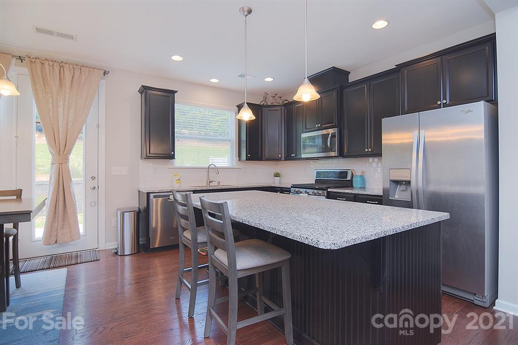 1411 Calum Way Fort Mill, SC 29708 - Photo 6 of 37 a kitchen with stainless steel appliances granite countertop a sink refrigerator and microwave