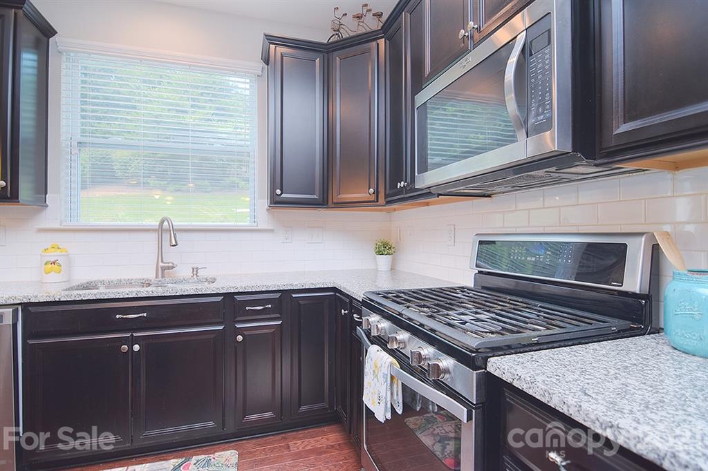 1411 Calum Way Fort Mill, SC 29708 - Photo 8 of 37 a kitchen with a sink stove and cabinets