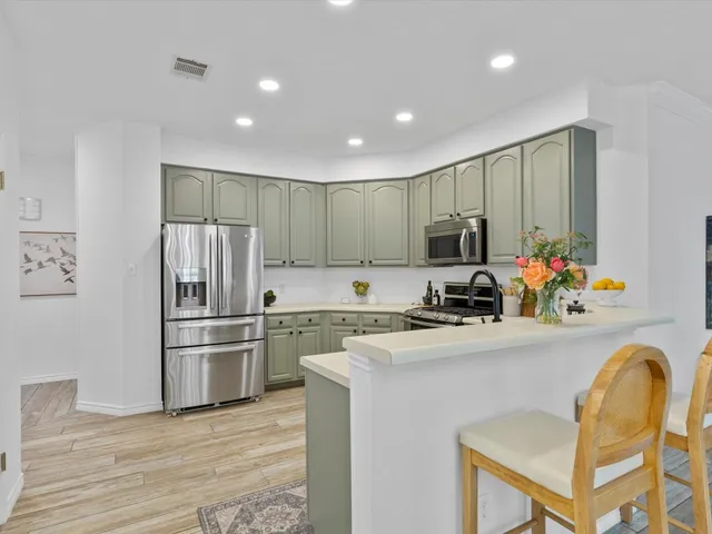 a kitchen with stainless steel appliances granite countertop a refrigerator and a stove top oven