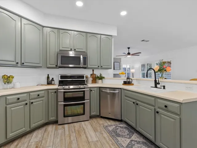 a kitchen with a sink cabinets and stainless steel appliances