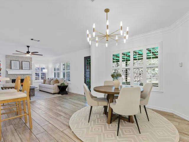 a view of a dining room with furniture a chandelier and wooden floor
