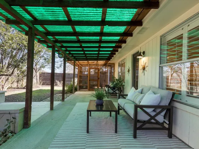 a living room with patio furniture and a potted plant