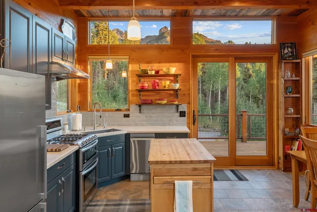 a kitchen with a sink a stove cabinets and glass door