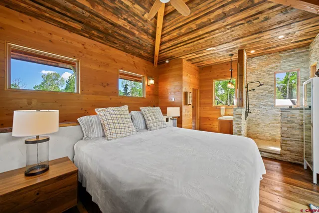 a large bed sitting in a bedroom next to a lamp