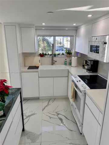 a kitchen with a sink a stove and cabinets