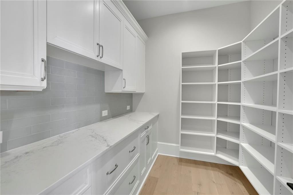 123 Candler Loop Acworth, GA 30101 - Photo 18 of 34 a view of an empty room with wooden floor and cabinets